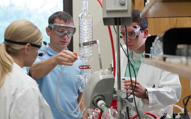 HU students and professor doing an experiment in the chemistry lab.